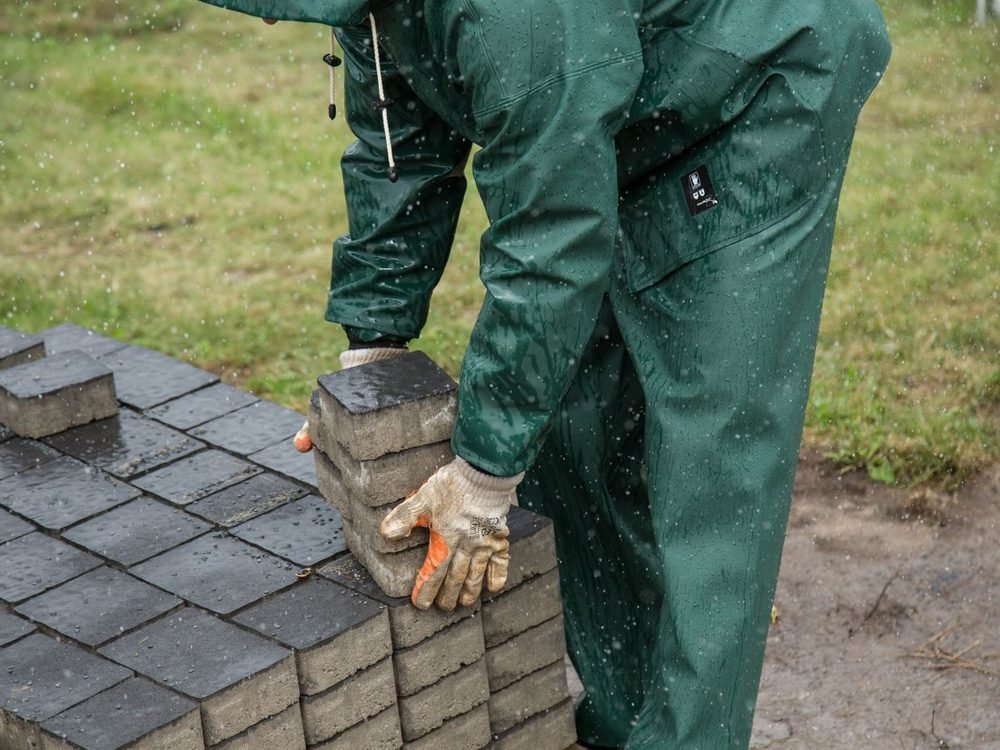 Hands setting paving stones