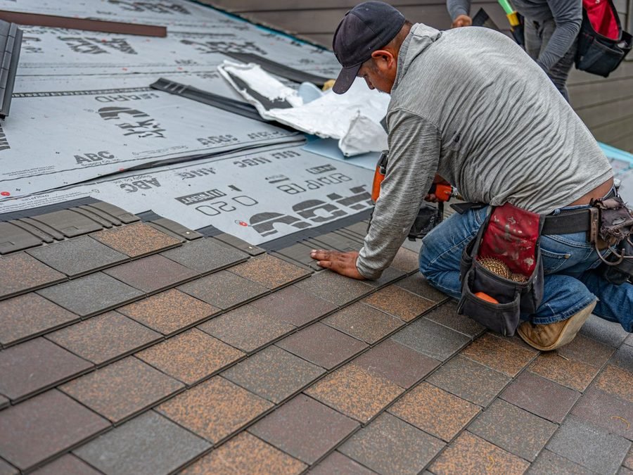 Roofer installing shingles